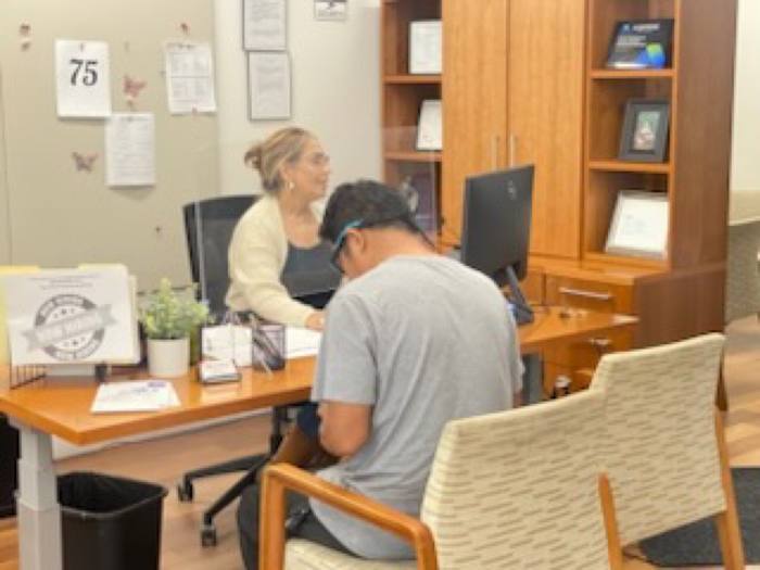 Agente bilingüe de Via Rapida atendiendo a un cliente en la oficina de San Jose