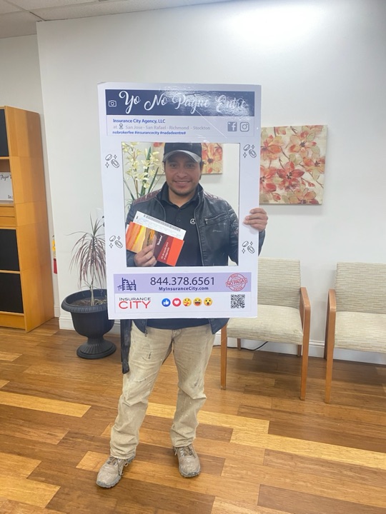 Stockton auto insurance policyholder holding Insurance City Yo No Pague Entre frame with new California policy documents