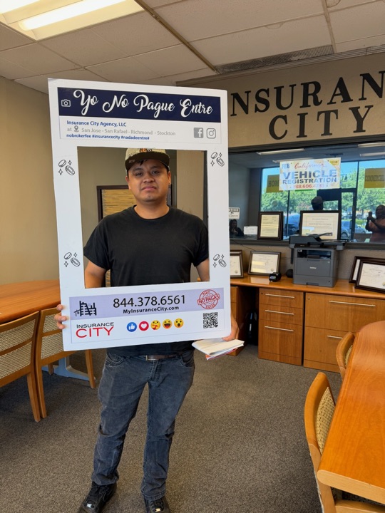 Cliente de Insurance City Stockton junto al mostrador de registro vehicular DMV — sin cuota de broker